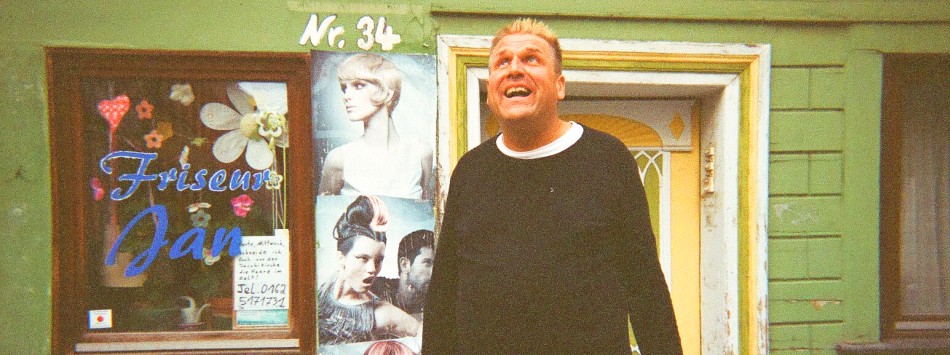 Portrait, lachend vor dem Salon mit der Hausnummer 34